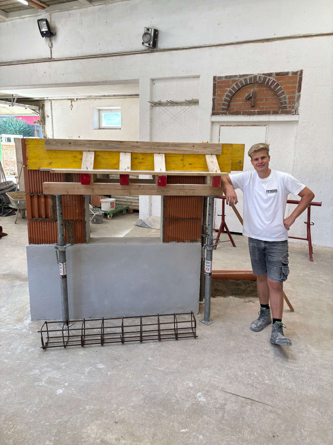 Lehrling präsentiert fertiges Übungsstück in der Bauhalle