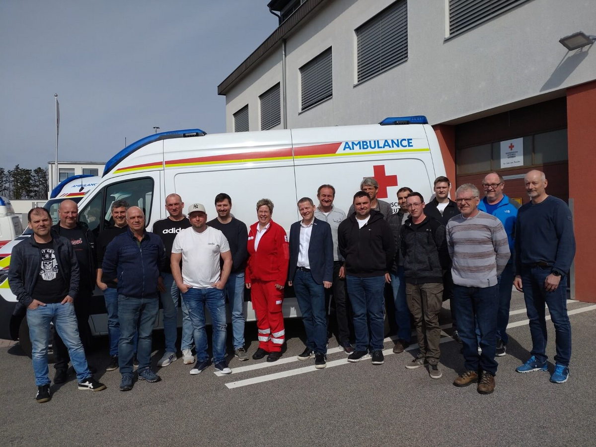 Teilnehmer des Erste-Hilfe-Kurses von Pfnier & Co GmbH vor einem Rettungswagen der Rot-Kreuz-Bezirksstelle in Oberpullendorf.