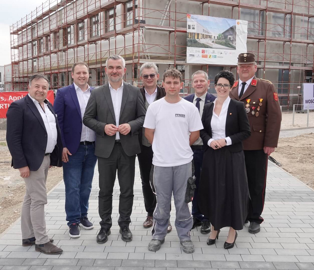 Gleichenfeier Ceramico Schulcampus Stoob – Gruppenfoto mit Projektbeteiligten vor Baustelle