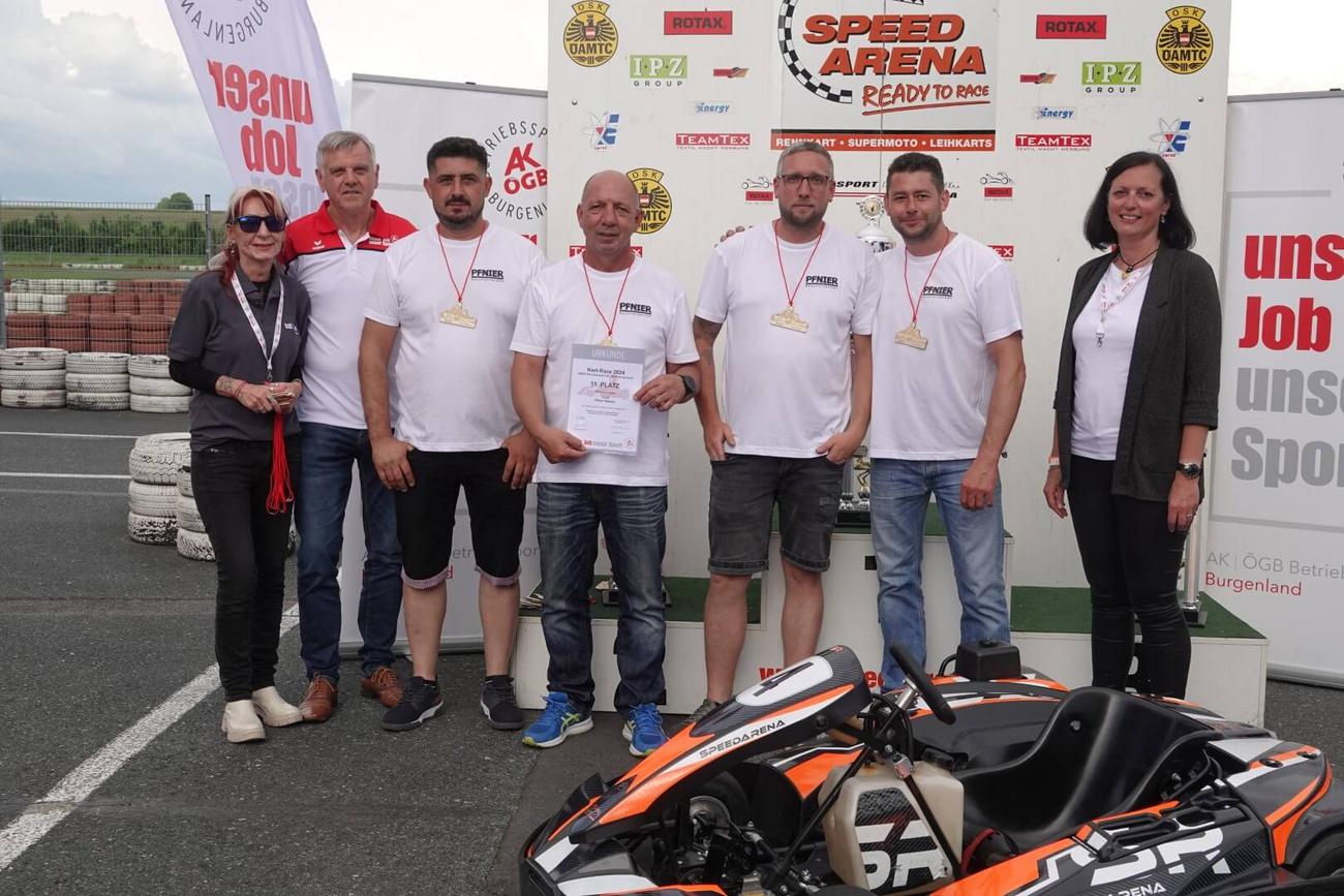 Das Team der Pfnier Racers bei der Siegerehrung des Kartrace 2024 in der Speedarena Rechnitz, mit ihren Medaillen und der Urkunde für den 11. Platz.
